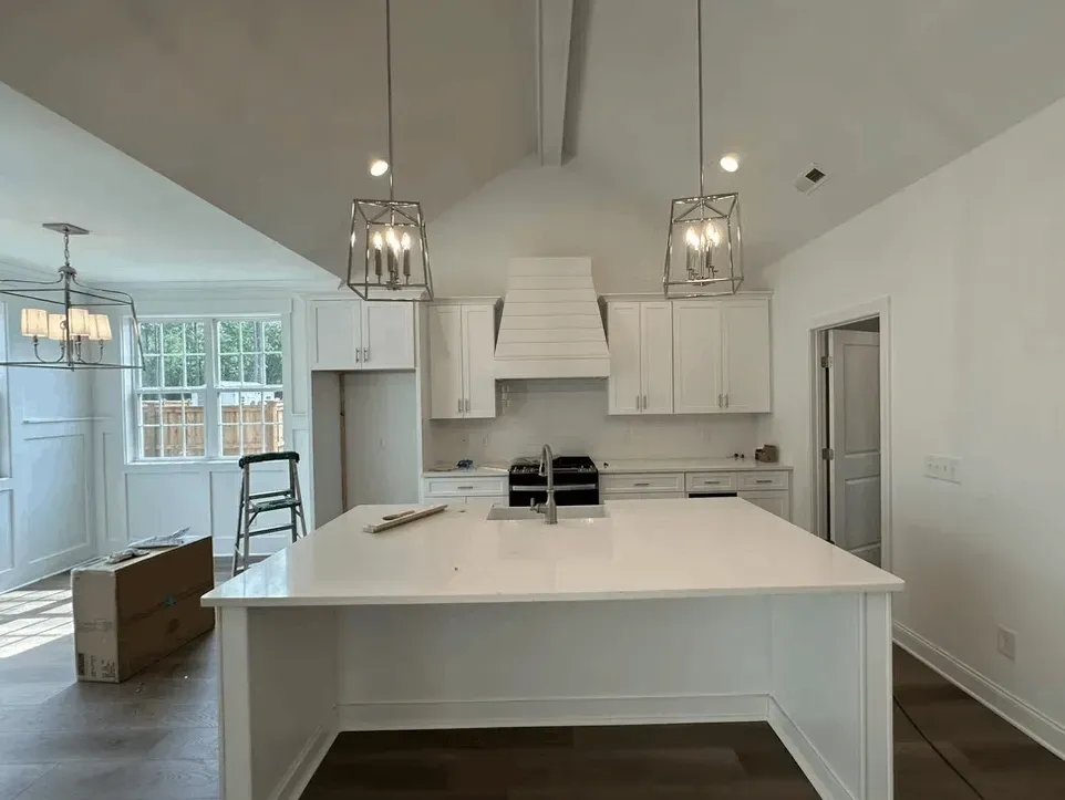 Bright modern kitchen remodel in Jacksonville NC with sleek cabinetry, granite island, stainless appliances, and inviting decor.