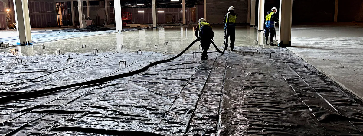 Operatives pouring flowing screed on a CSC Screeding site