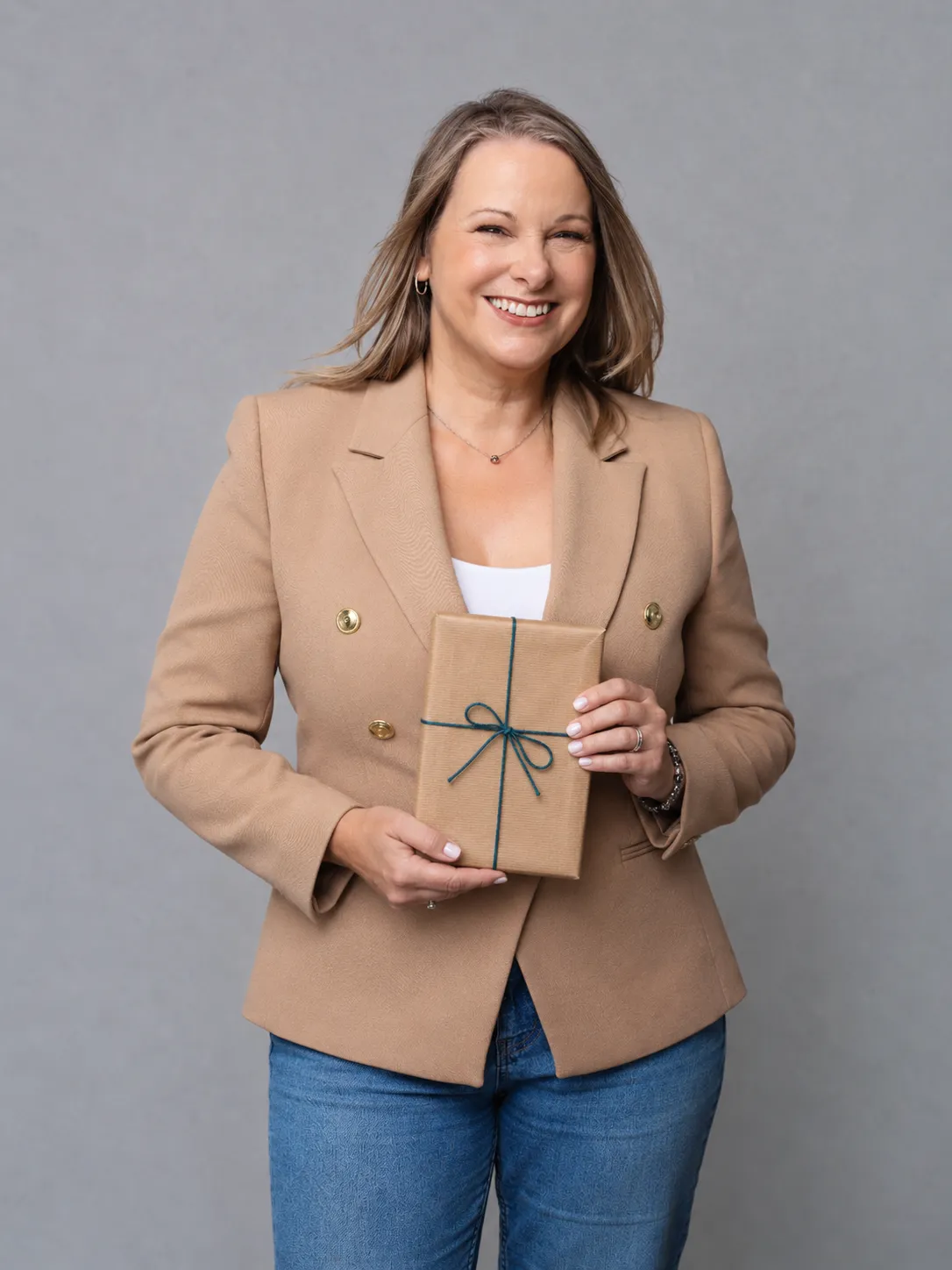 Jo Wildsmith holding a book in brown paper packaging