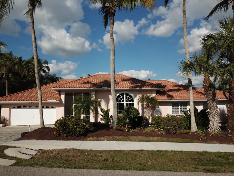 a red car parked on top of a roof next to a body of water