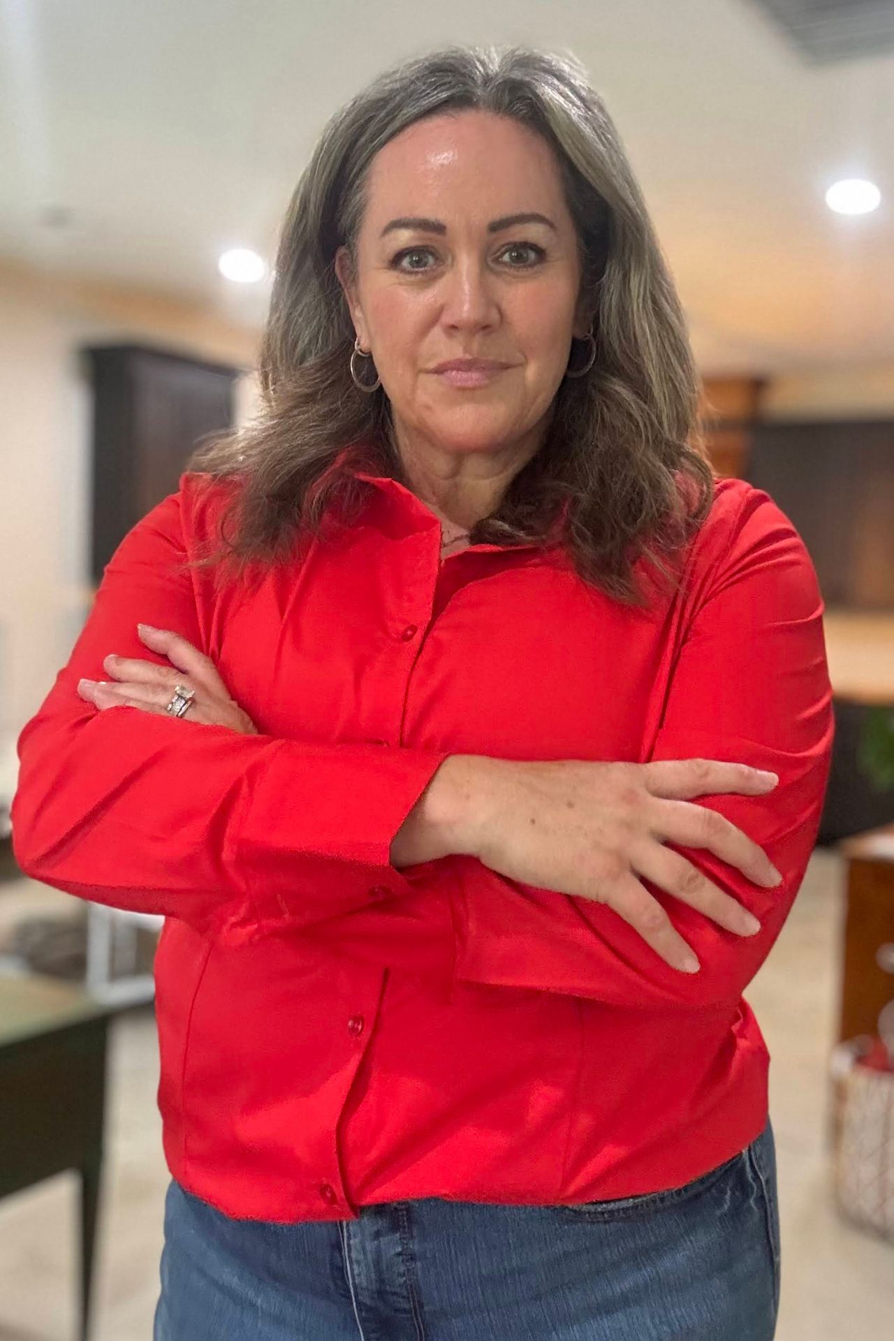 Carmen Ball standing with arms crossed in a red blazer
