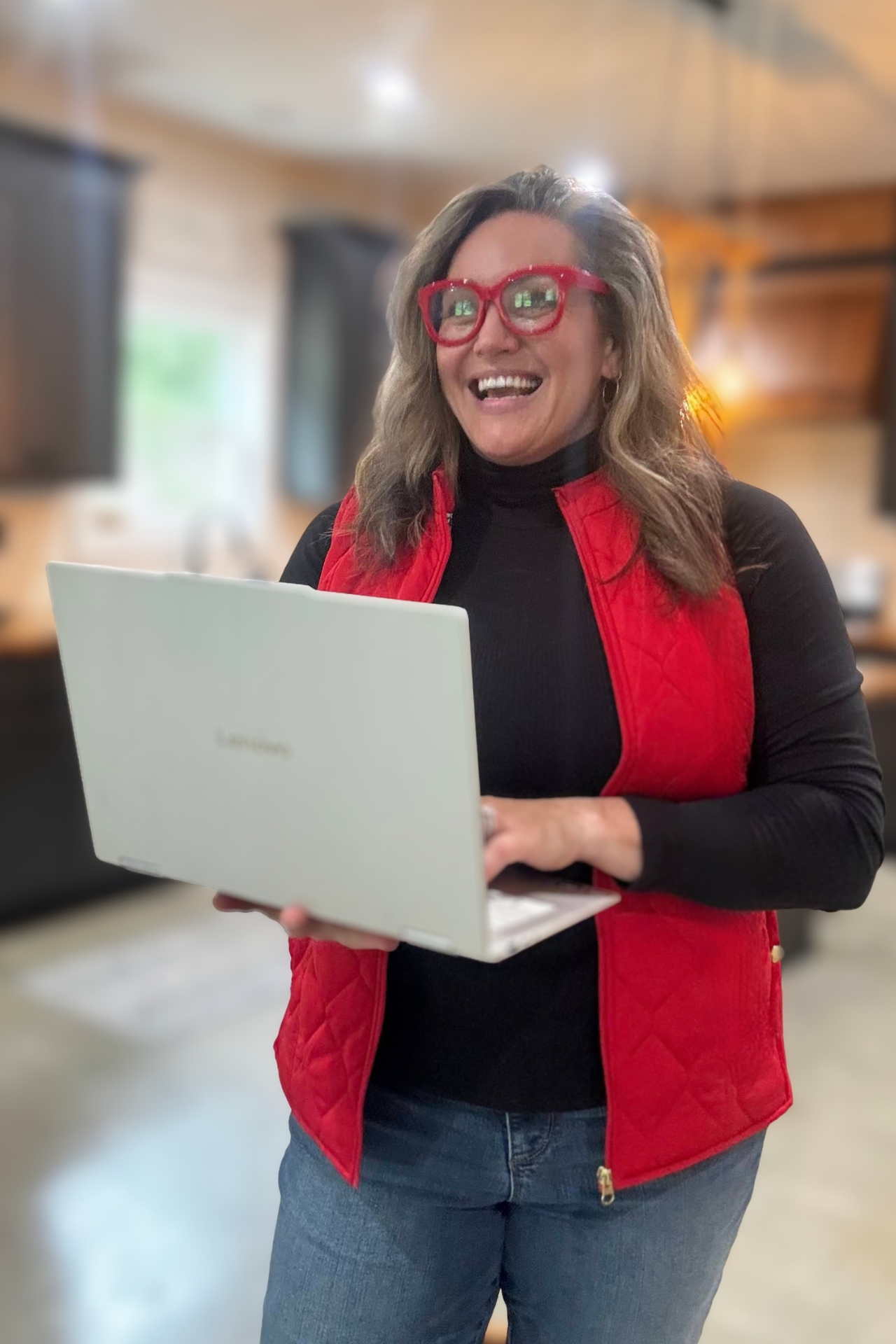 Carmen Ball standing and holding a laptop