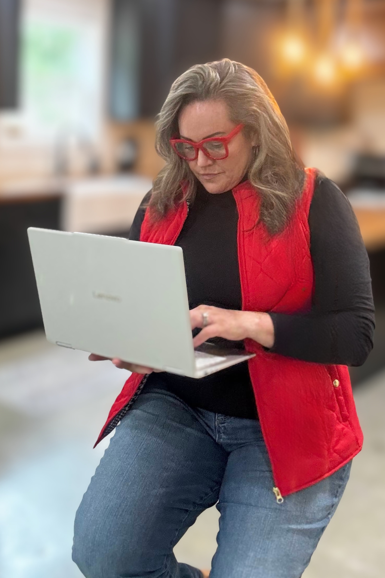 Carmen Ball kneeling and working on a laptop