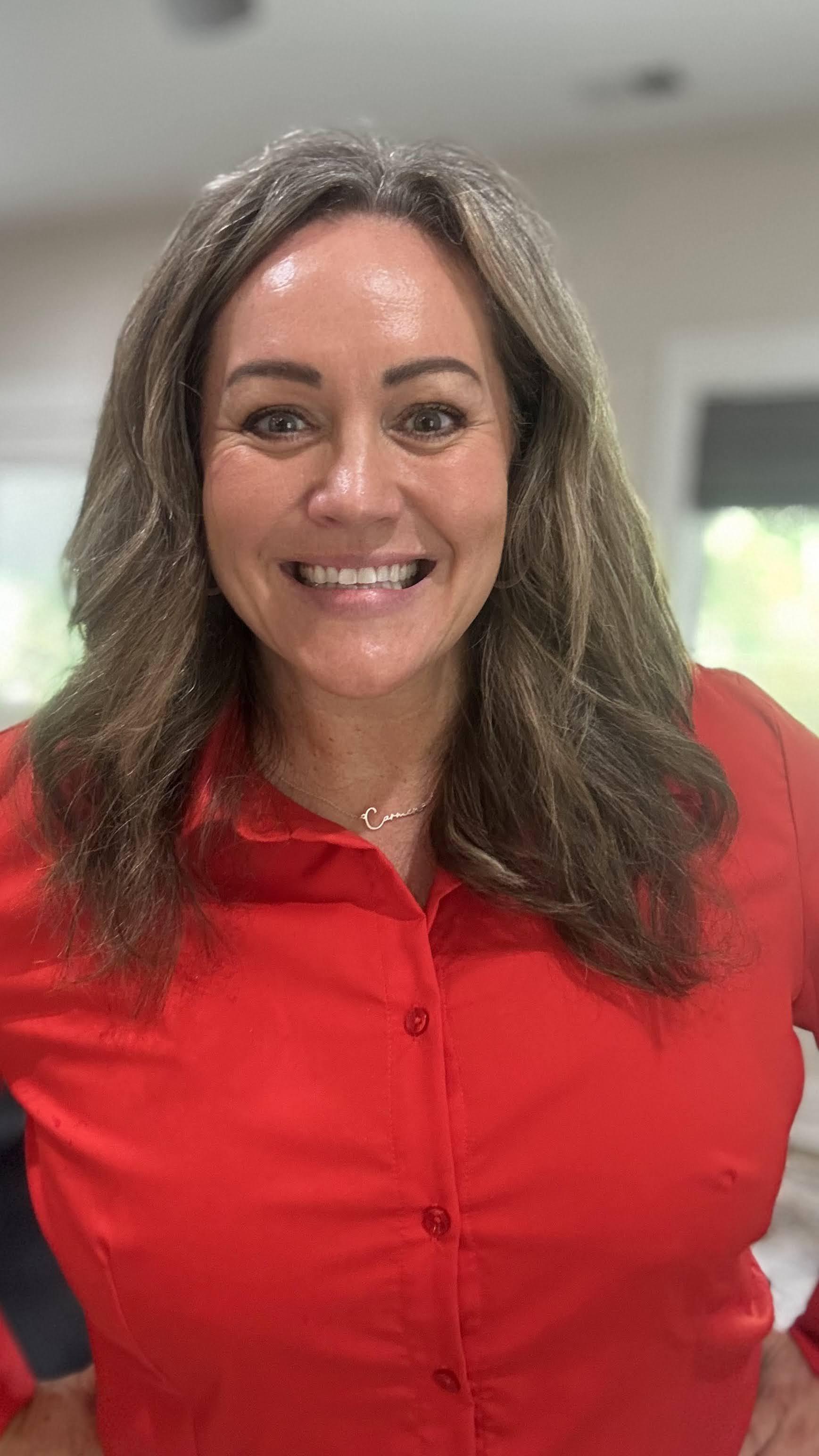 Headshot of Carmen Ball smiling in a red top