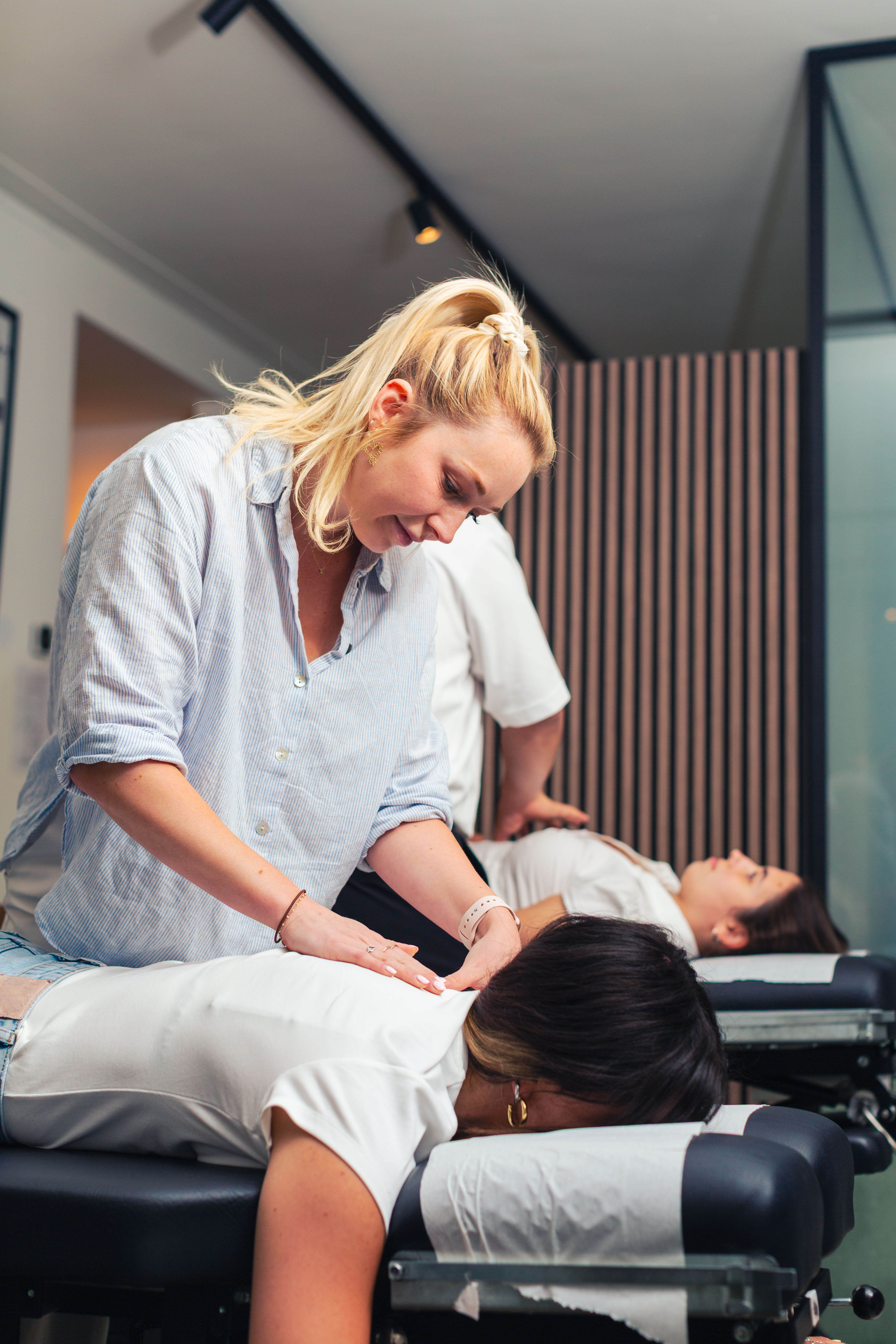 a chiropractor from one chiropractic studio making a neck adjustment on a teenager