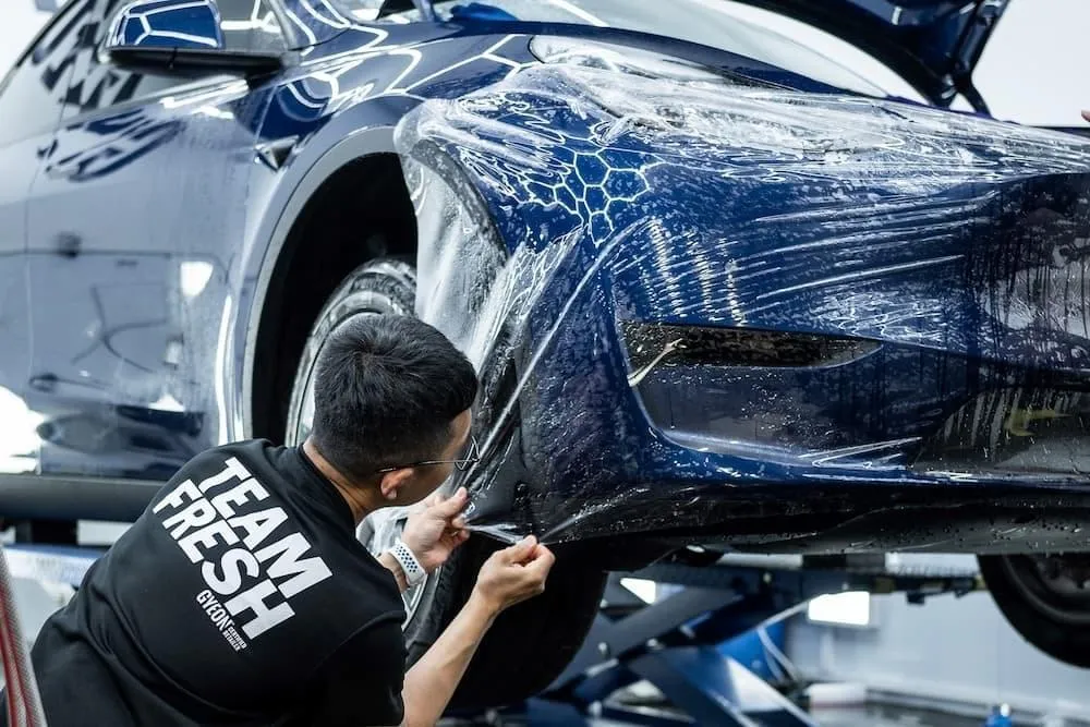 PPF Film being applied to the front bumper of a Tesla
