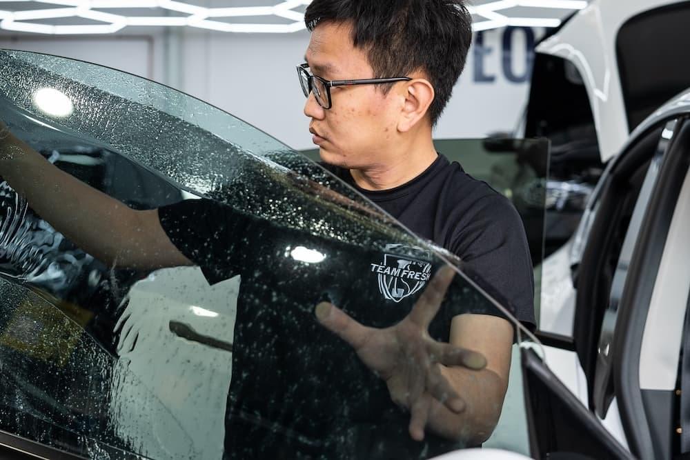 Local tinting expert installing street legal tint on front window