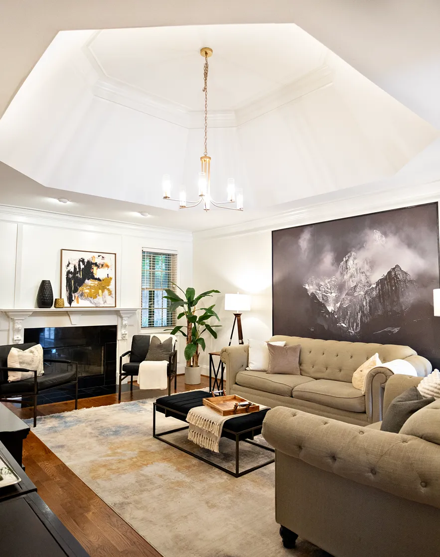 Traditional style living room showcasing a light brown linen sofa and loveseat, recessed ceiling, and golden chandelier.