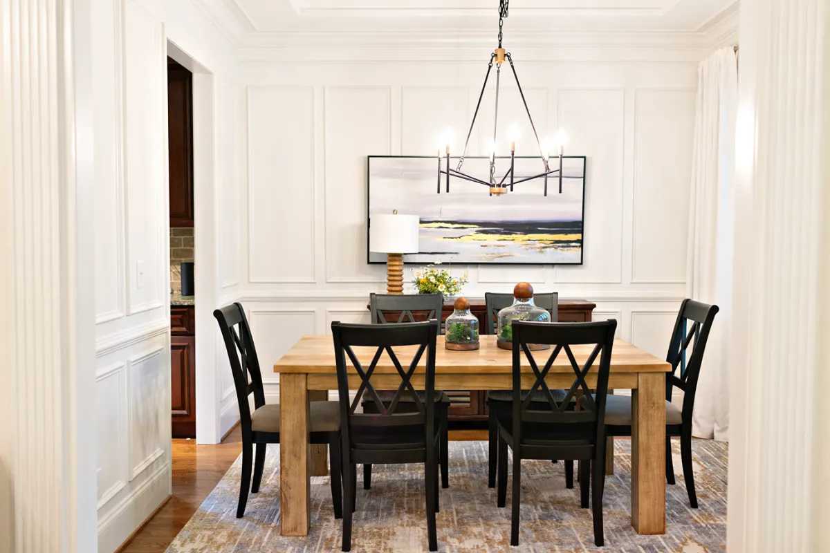 Traditional-style dining room with a rustic wooden table, ladder-back chairs, and sleek metal chandelier.