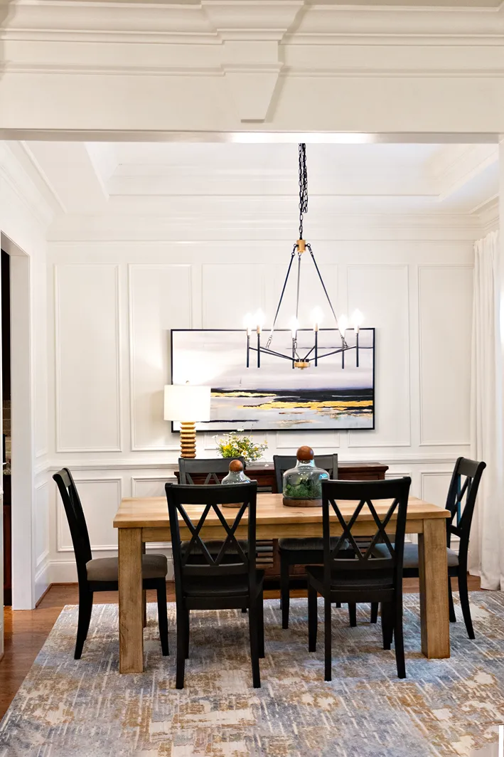 Traditional-style dining room featuring an earthly design with wooden table, dark chairs, and a rustic area rug.