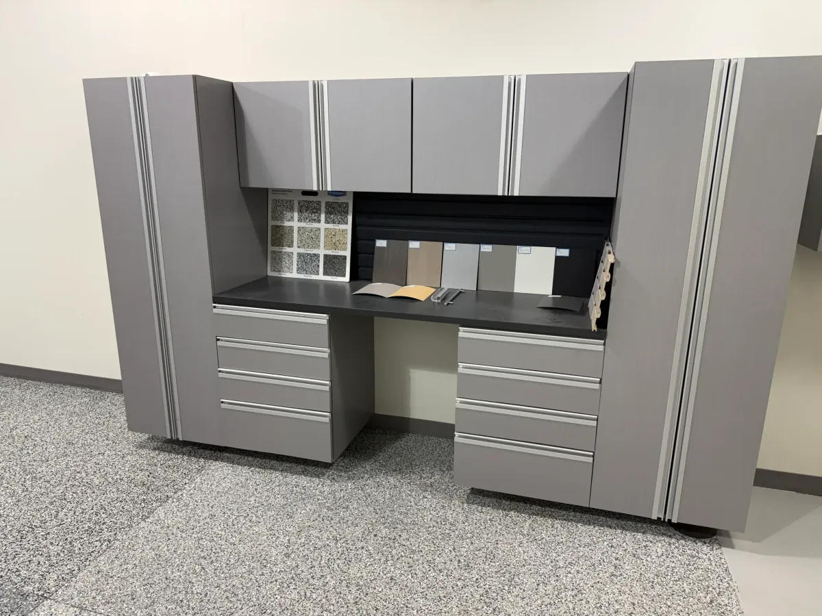 A stunning, newly renovated garage with a gleaming floor coating and sleek cabinets, tools neatly organized, and plenty of space for vehicles and storage.