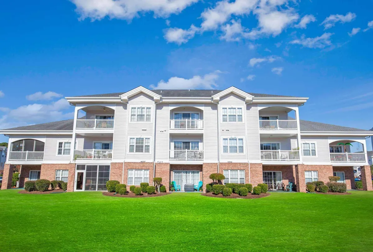 Font view of condos with green grass