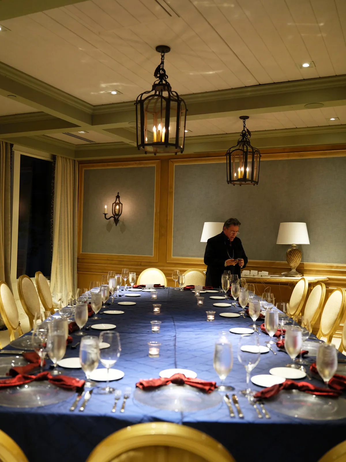 Long dinner table set with glassware and red napkins in a private dining room