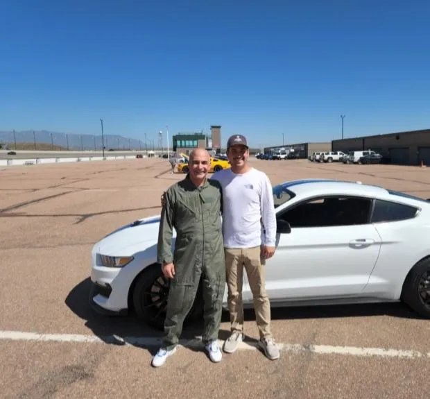 Family-owned sign company team from SignSmiths of Texas in Wylie, TX standing beside a Shelby Mustang.