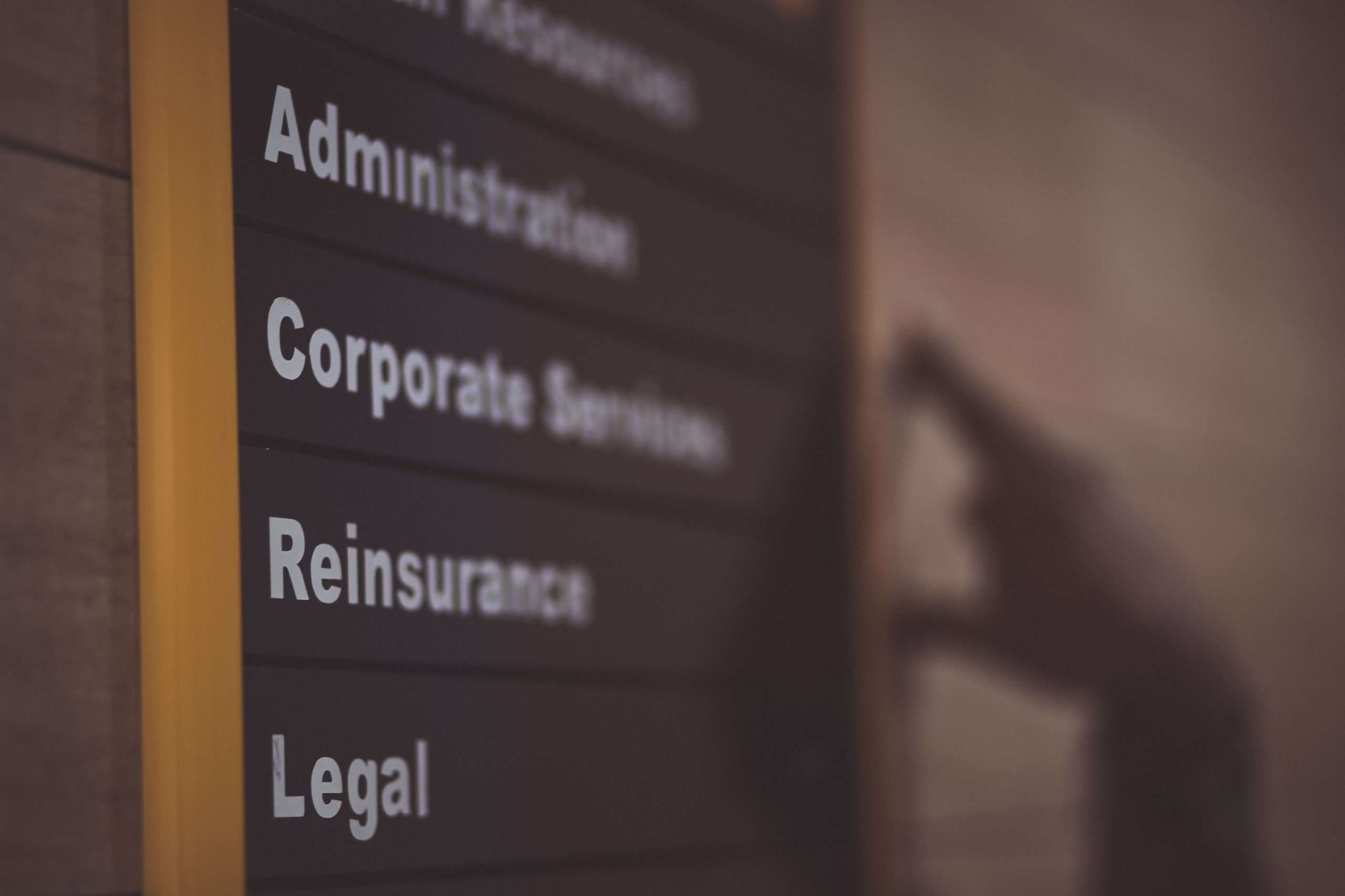Graphic with the headline "Ensuring Business Compliance with ADA Signs," accompanied by text elements "Corporate Services" and "Reinsurance."
