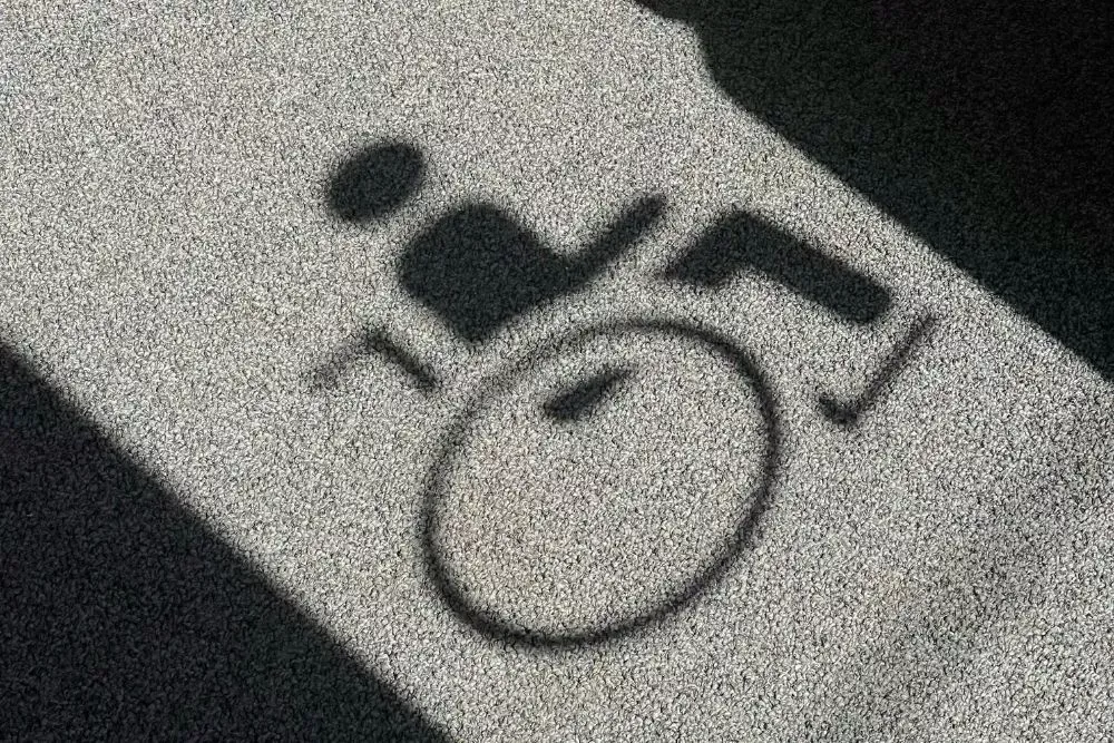 Wheelchair accessibility symbol floor graphic applied on concrete, used for ADA compliant floor markings, accessible pathways, and wayfinding signage in commercial buildings and public spaces.