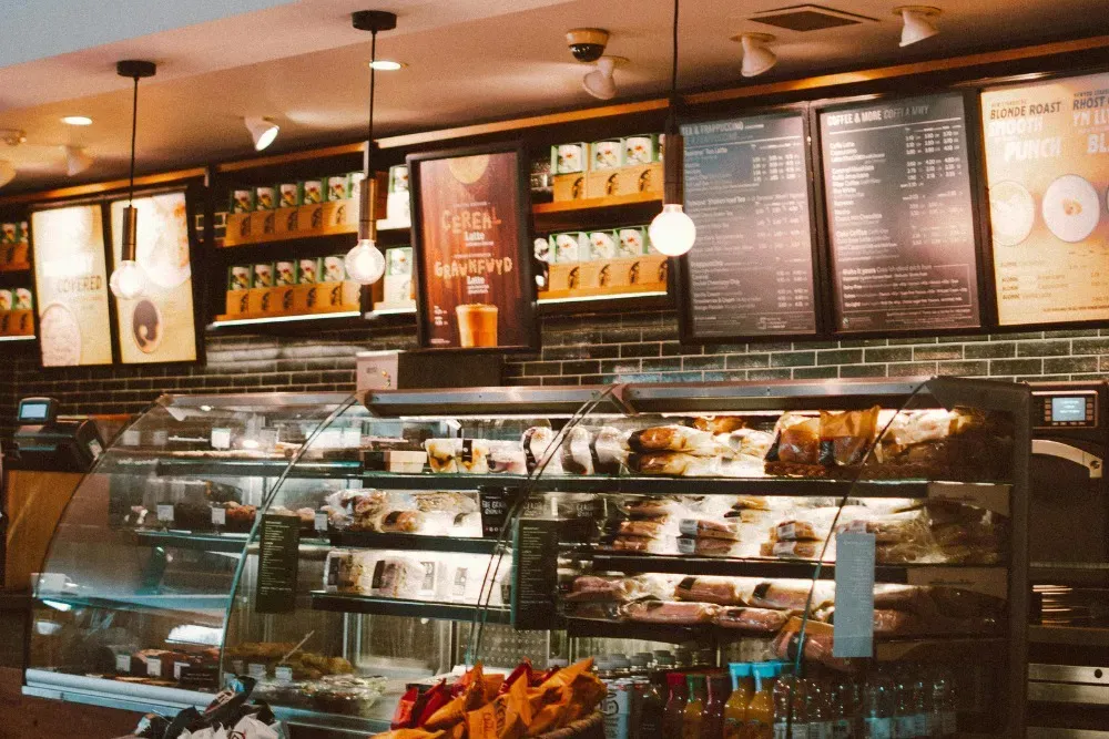 Restaurant menu boards displayed behind a café counter, used for food menu signage, digital or printed menu displays, and improving customer ordering experience in restaurants and coffee shops.