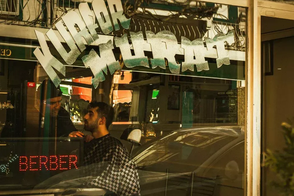 Barber shop storefront with vintage style barber signage and window lettering, used for barbershop branding, storefront signs, and attracting walk in customers.