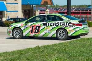 Custom vinyl car wrap with business branding installed on a vehicle