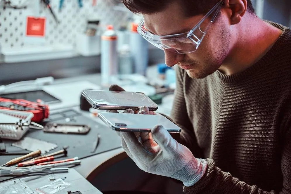 Technician repairing a smartphone’s internal components at Cellular Repair 1