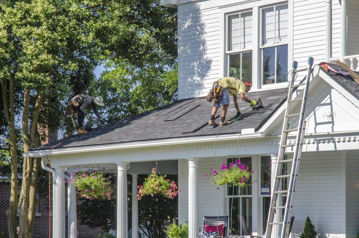 Residential roofing project featuring a modern white house with a newly installed asphalt shingle roof