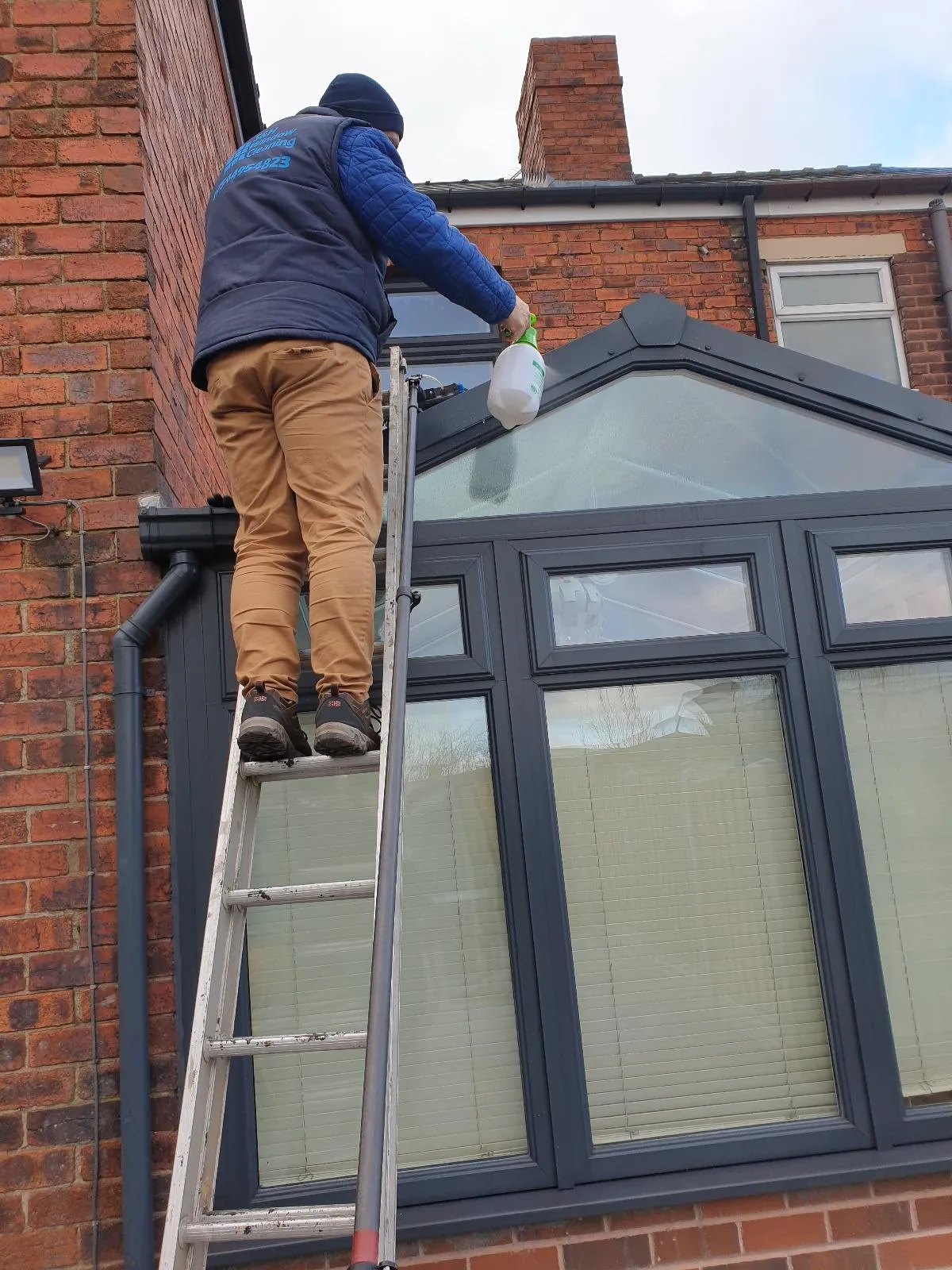 Team member cleaning a conservatory roof 