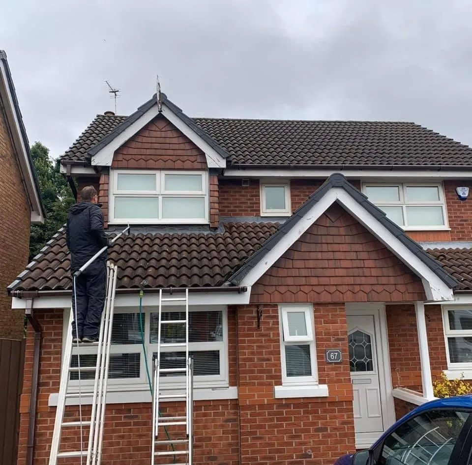 Team member cleaning a roof 