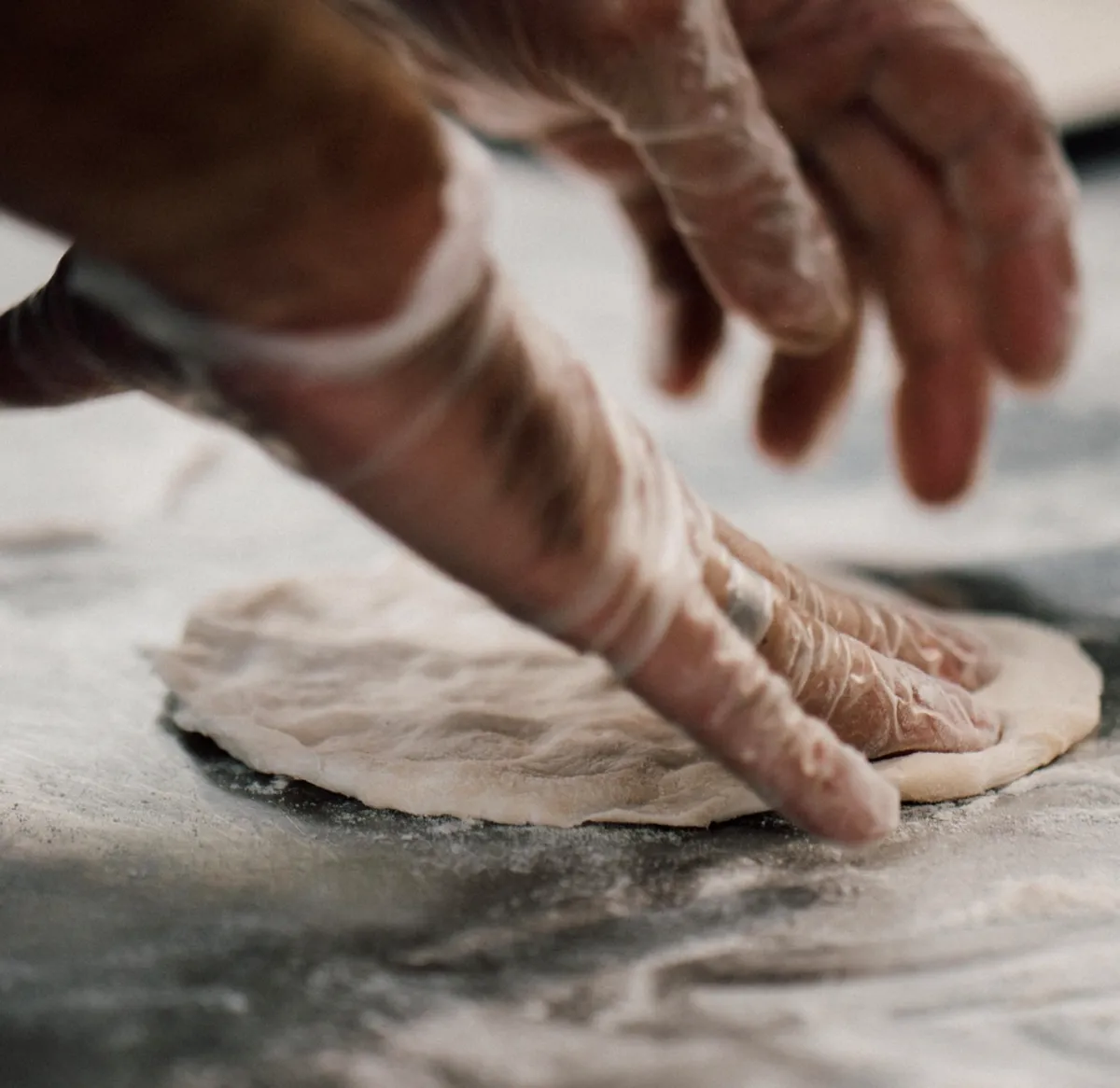 Chef rolling dough by hand