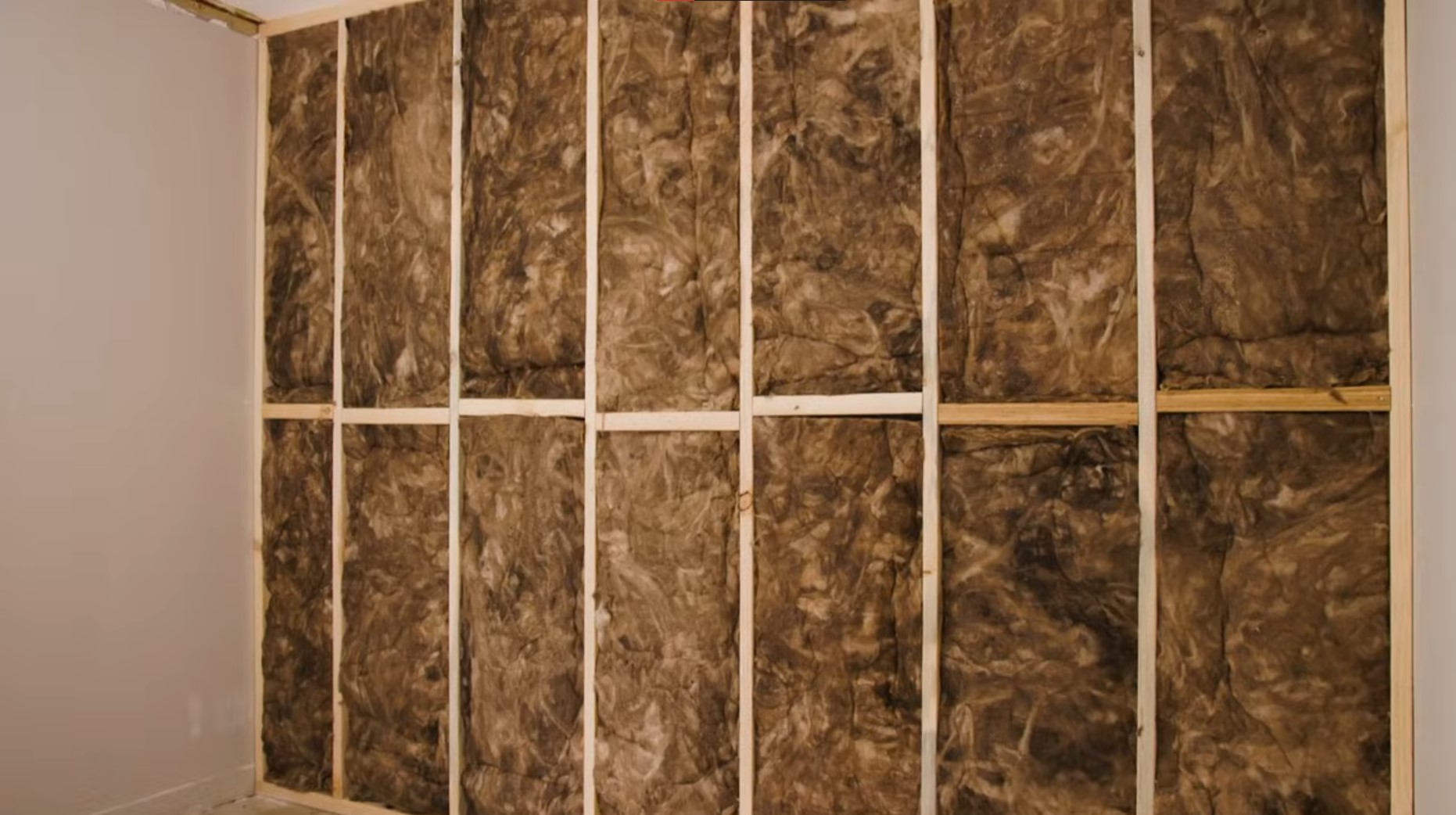 brown fibreglass insulation installed into wall