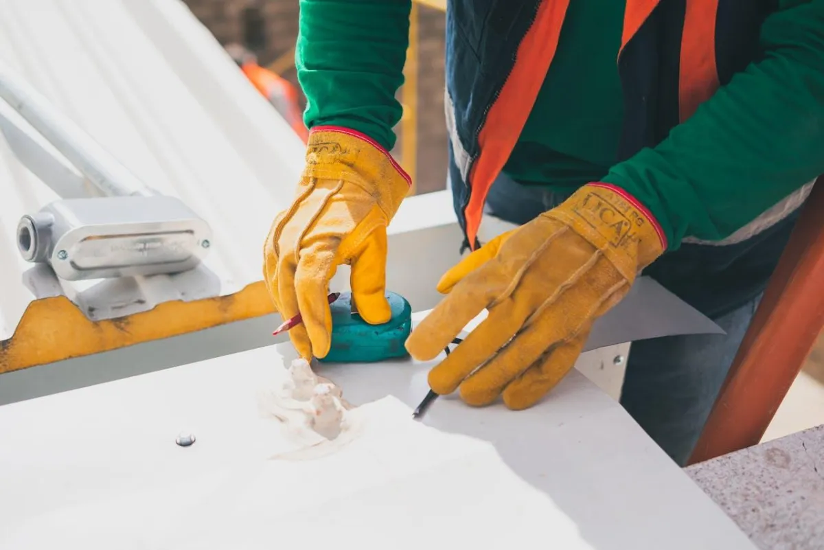 Contractor marking materials with protective gloves during commercial renovation project for safety and precision.