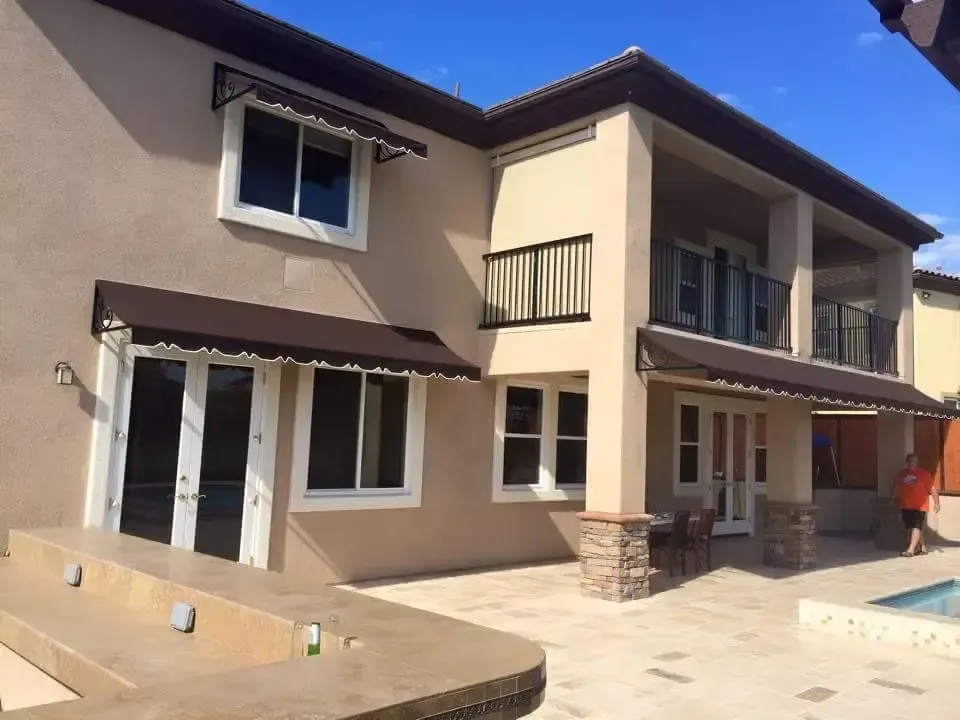 Dark brown custom patio and window awnings with white trim installed on a two-story home in Garden Grove, CA