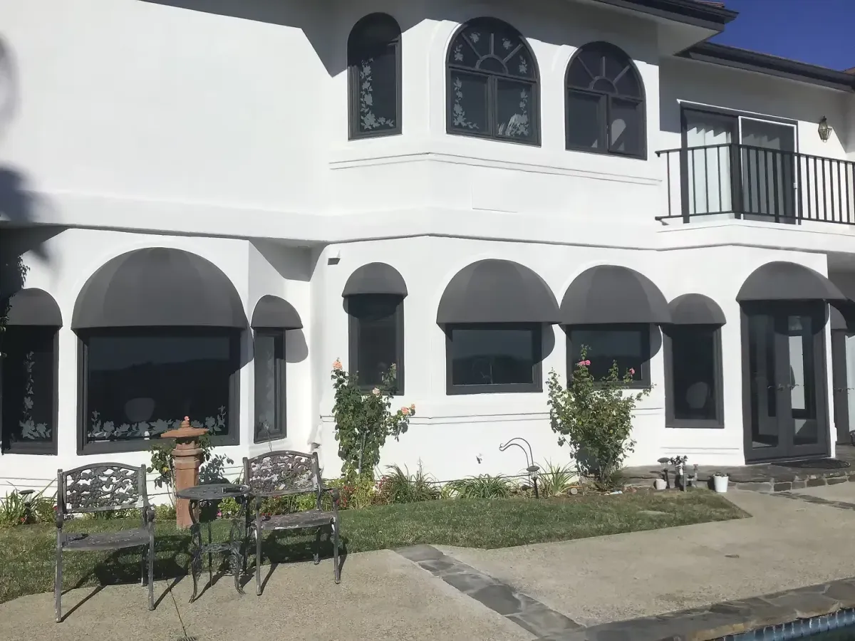Custom black dome window awnings installed on a white residential home in Yorba Linda, CA
