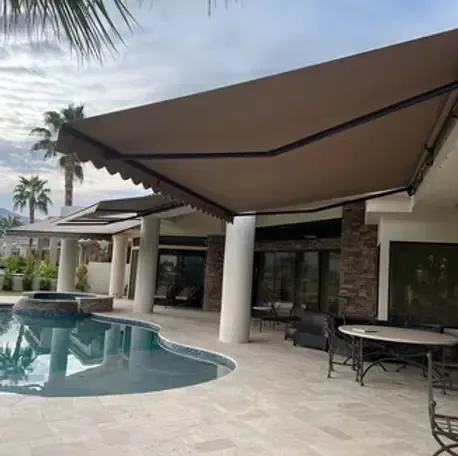 Large mocha retractable patio awning shading a pool deck at a home in Westminster, CA