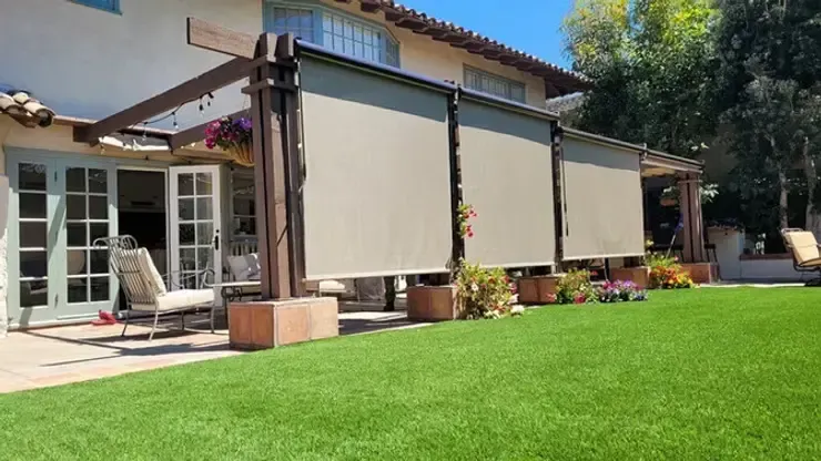 Tan motorized vertical drop shades installed on a custom dark wood patio pergola in Anaheim, CA