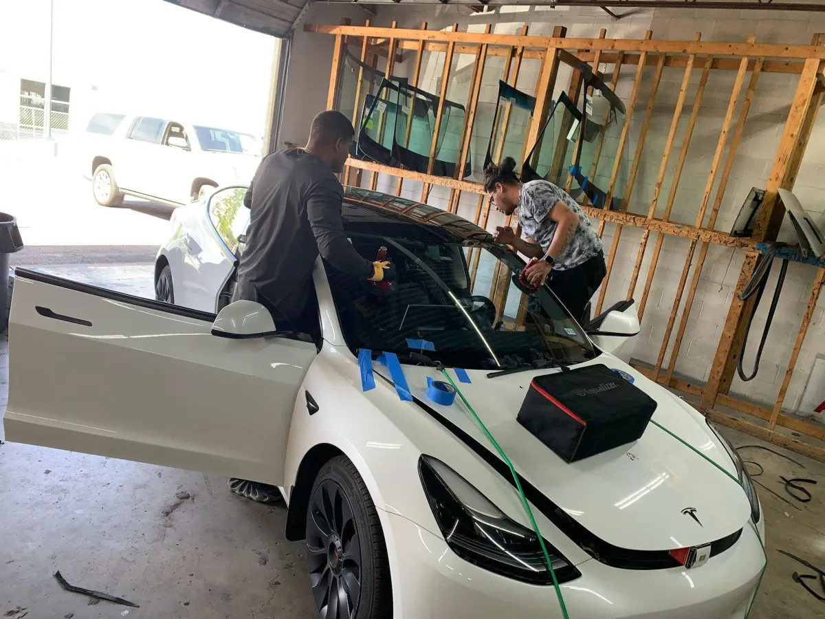 A woman riding a bike down a street next to tall buildings