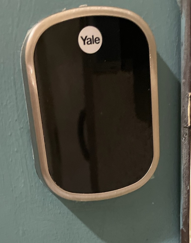 A diverse team of locksmiths in branded uniforms standing in front of a Coastal Keys Locksmith van, smiling and ready to assist. The background shows a residential street in Panama City, emphasizing local trust and professionalism.