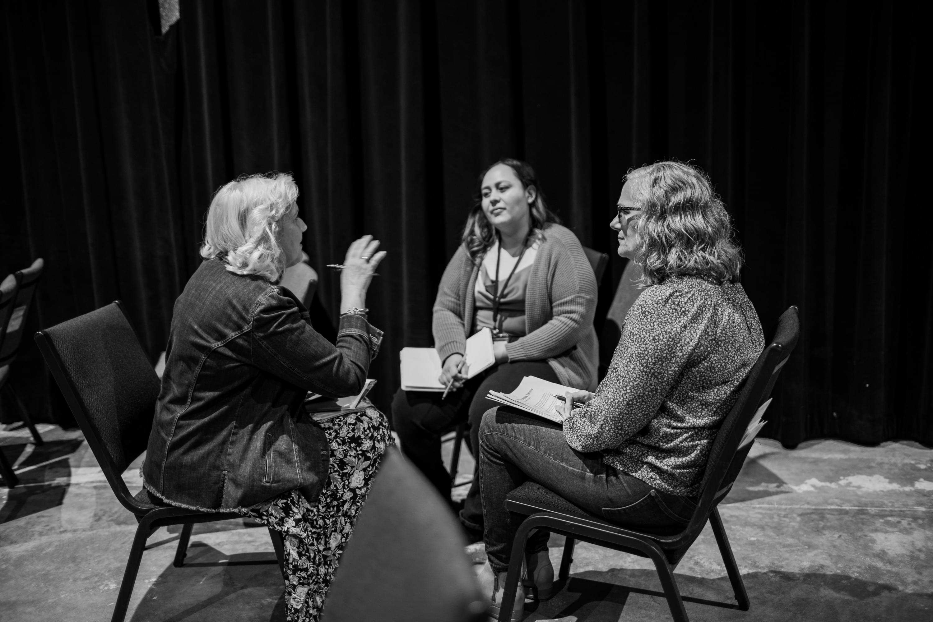 silhouette of person sitting on bench near body of water during daytime