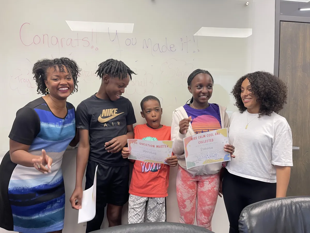 person writing on brown wooden table near white ceramic mug