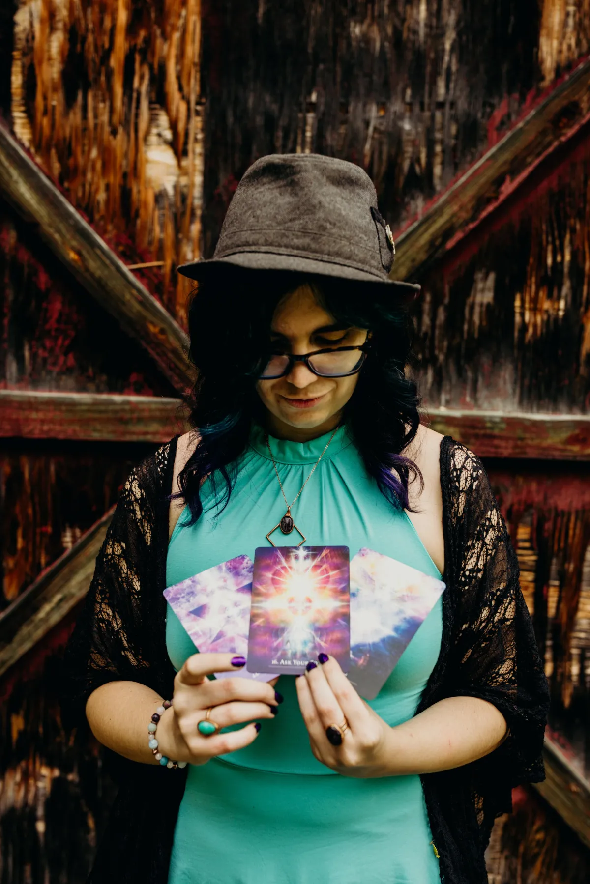 A warm, softly lit table with a unique spread of twelve illustrated oracle cards, each card featuring a different symbolic image, surrounded by a journal, a candle, and a cup of herbal tea. The scene is inviting, with gentle golden tones and a sense of calm, designed to evoke reflection and anticipation for the year ahead.