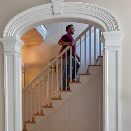Crisp white trim and entryway walls freshly painted by By Hand Painting for a polished interior finish