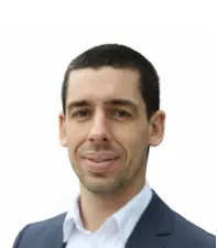 Professional portrait of a man in a suit, representing leadership and innovation in AI initiatives.
