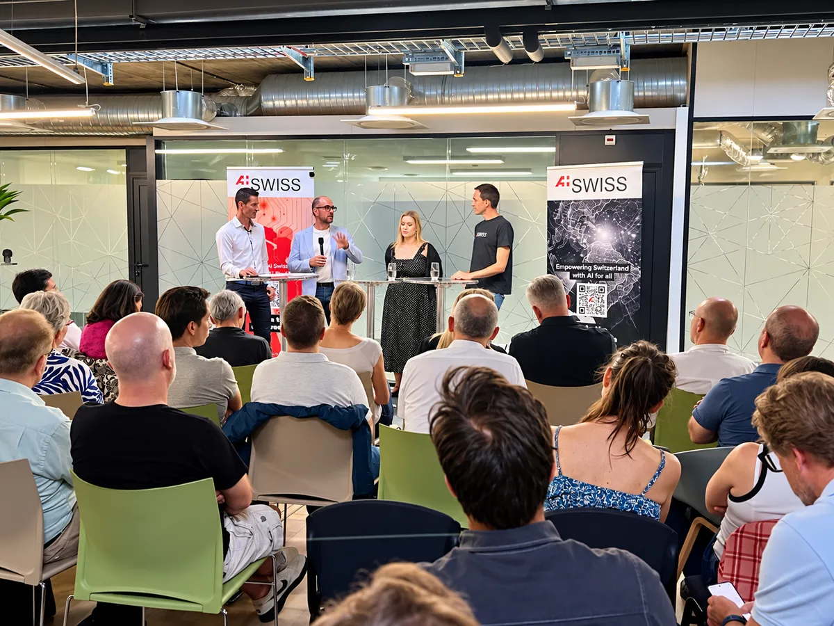 An AI Swiss panel discussion in front of an audience.