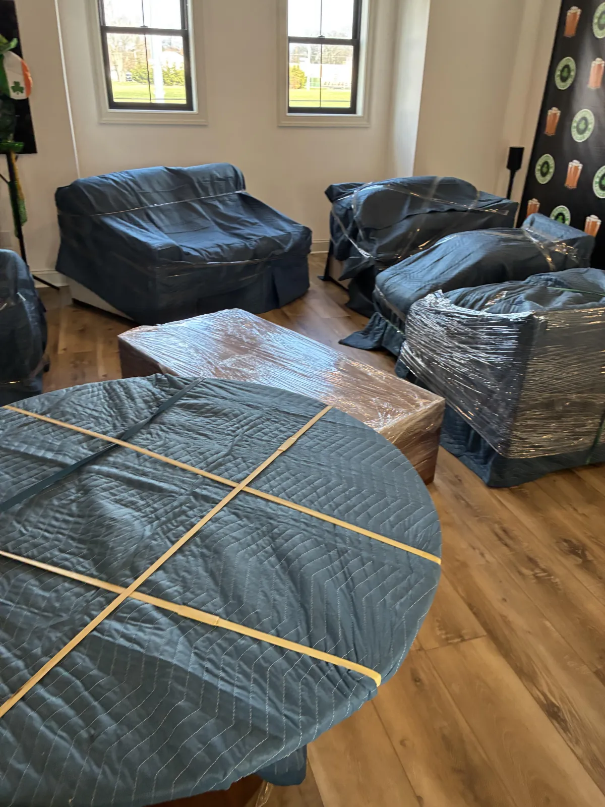 Room with stacked moving boxes, a small table, and a chair, showcasing a prepared space for moving services by Keep It Moving Services NJ.