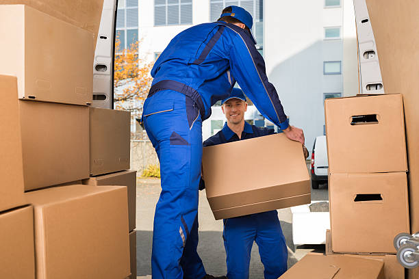Two professional movers loading boxes into a moving truck.