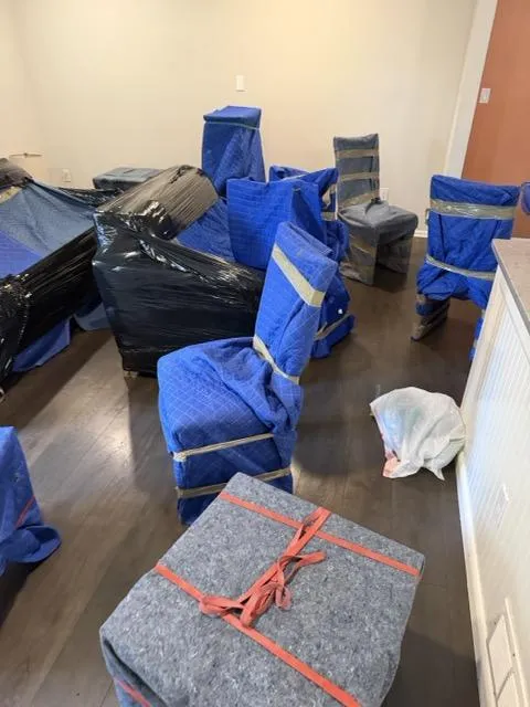 Living room furniture wrapped in blue moving blankets — professional KIMS prep work for a New Jersey move