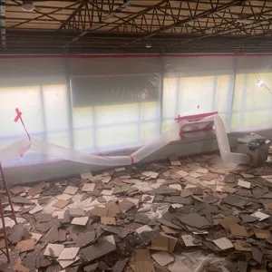 Masive pile of emovedwal and celing upon the floor with a ventiation machine filtering out the demolition air pollutants.