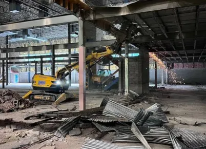 Masive pile of emovedwal and celing upon the floor with a ventiation machine filtering out the demolition air pollutants.