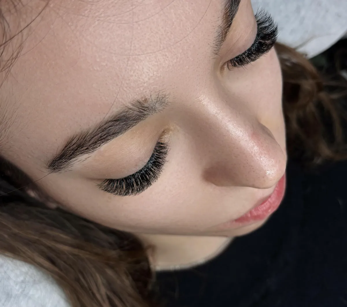 Tight crop of an eye with long curled lashes and precise eyeliner, high-detail, shallow depth of field, studio lighting accentuating lash separation and texture, dramatic but natural result.