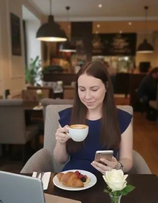 "Business owner happily looking at their phone, indicating freedom from daily tasks"