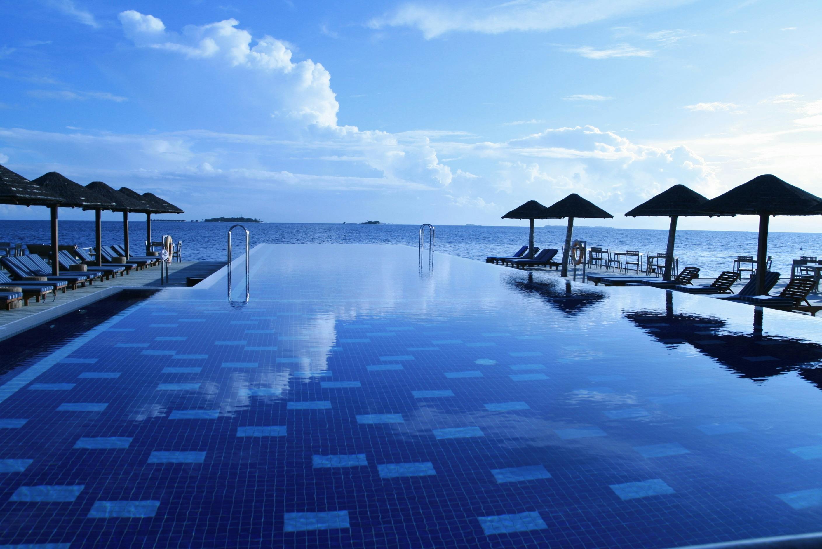 Infinity pool with blue water looking into the distant blue sky